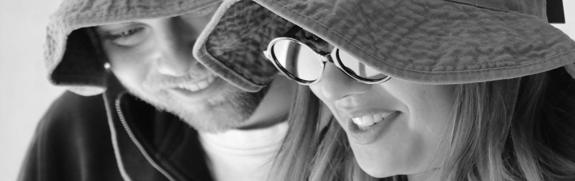 Deux étudiants qui sourient avec des bob sur la tête et des lunettes de soleil